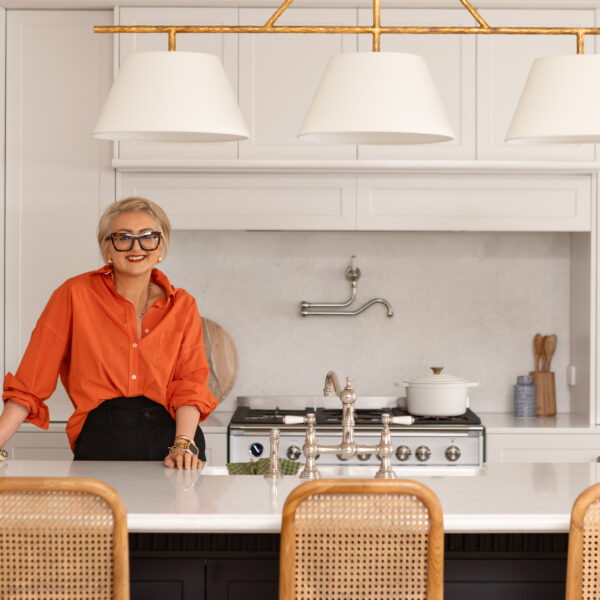 Designer in a modern French provincial kitchen with a bright orange shirt