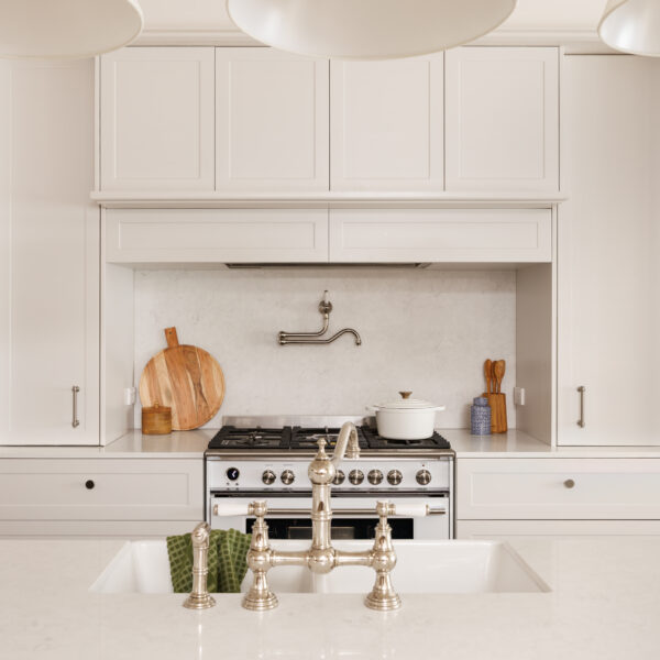 Modern French Provincial kitchen with white cabinetry and a central sink