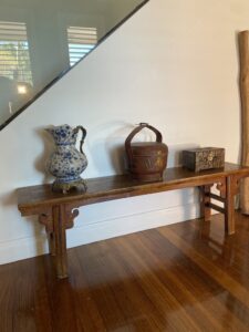 Antique vase, basket, and box on a wooden bench at Beaumaris Project Gallery