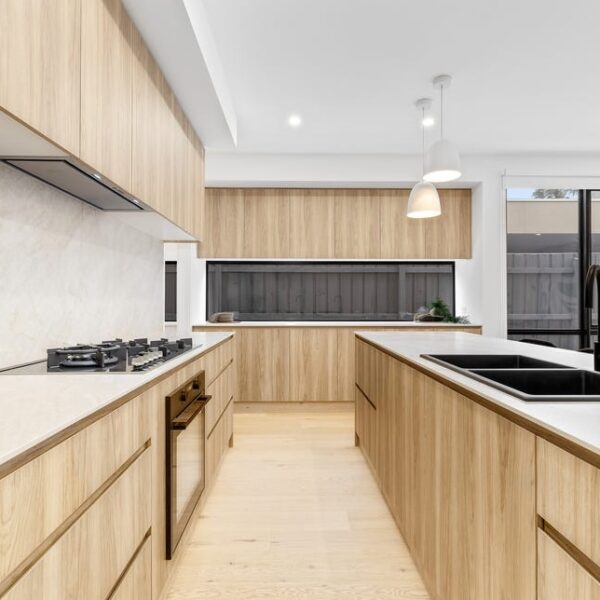 Modern kitchen with wood cabinetry and dual sinks