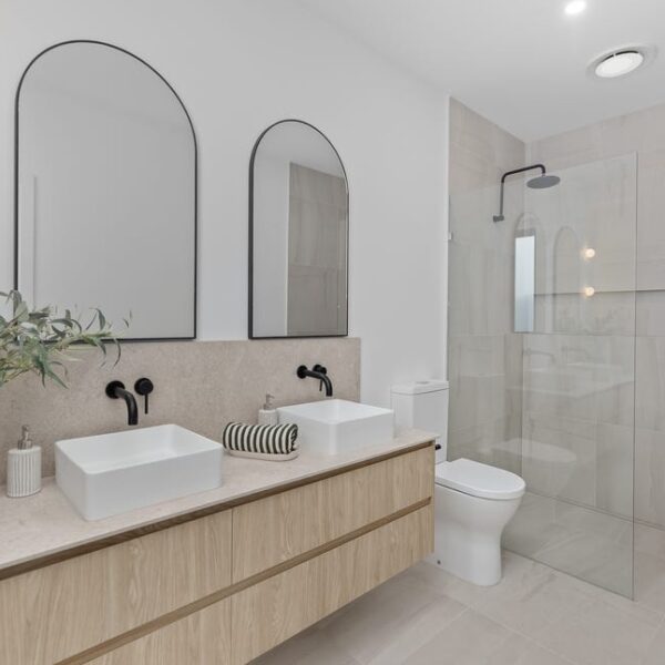 Modern bathroom featuring a double vanity and glass shower, ideal for residential design services
