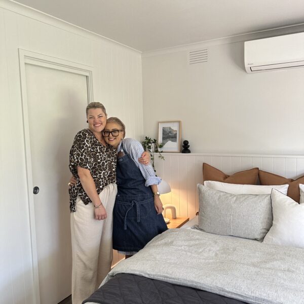 Two smiling women in a stylishly designed bedroom from the Keilor Project Gallery.