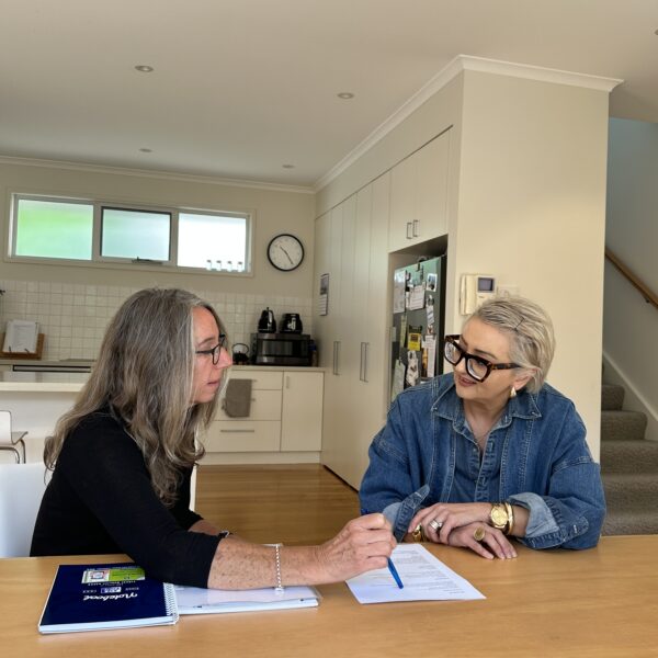 Two women discussing plans in a home interior setting