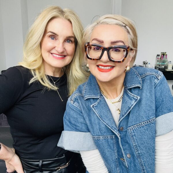 Two women smiling inside an interior design studio.