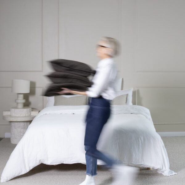Person blurring past a well-appointed bedroom in an interior design gallery