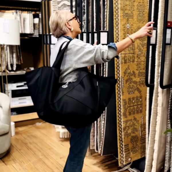 Woman browsing rugs in an interior design gallery