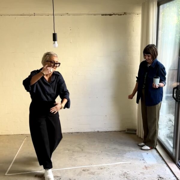 Two women discussing interior design layout in a minimalistic room
