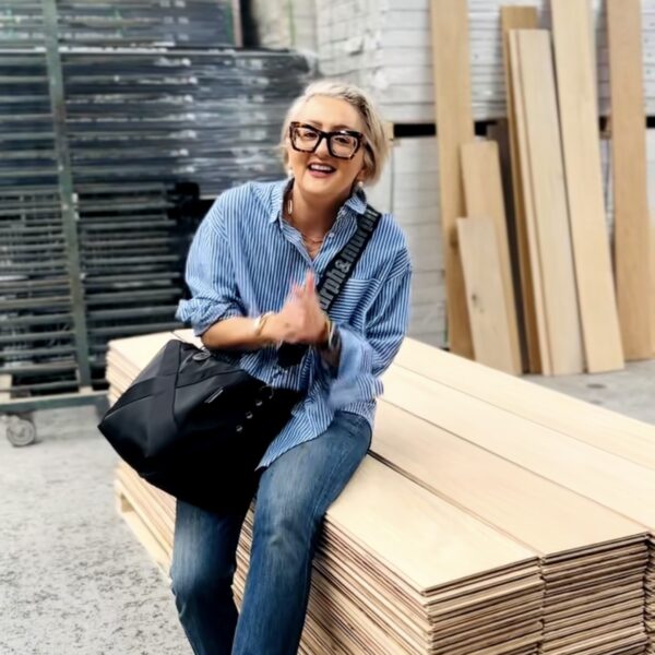 Person sitting on timber boards in interior design gallery