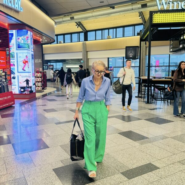 Person walking in an airport terminal with shops around