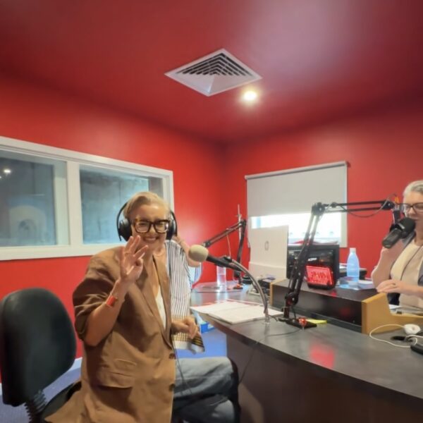 People recording a podcast in a vibrant red studio.