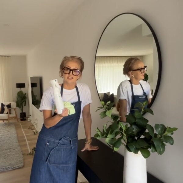 Interior designer holding a cleaning product in a stylish room
