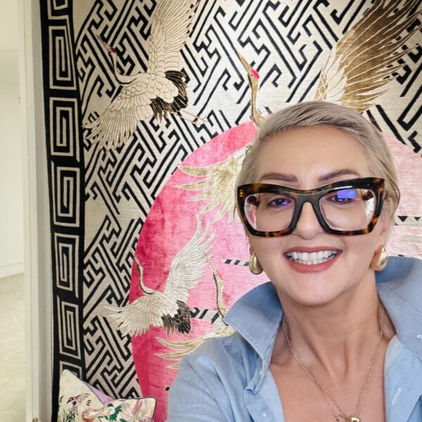 Smiling person in an interior design gallery with crane artwork