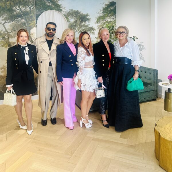 Group posing in stylish outfits at an interior design gallery