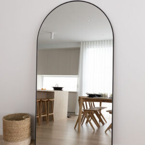Stylish interior of a beachside townhouse with a large arch mirror.