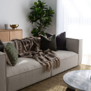 Stylish living room with a neutral sofa and green accents in a beachside townhouse.