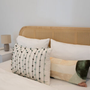 Stylish bedroom interior in beachside townhouse with decorative cushions