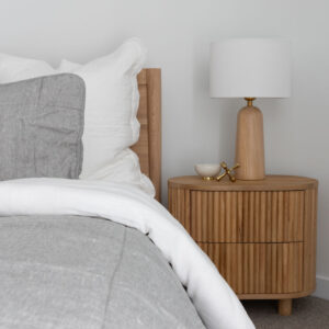 Elegant beachside townhouse bedroom with wooden side table