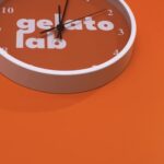 Wall clock with Gelato Lab branding on orange background.